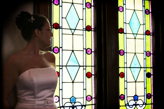 Kathy by the brilliant colors of the vintage stained glass windows of the historic Richmond, Indiana Wedding Chapel, Richmond Indiana wedding ceremony site.